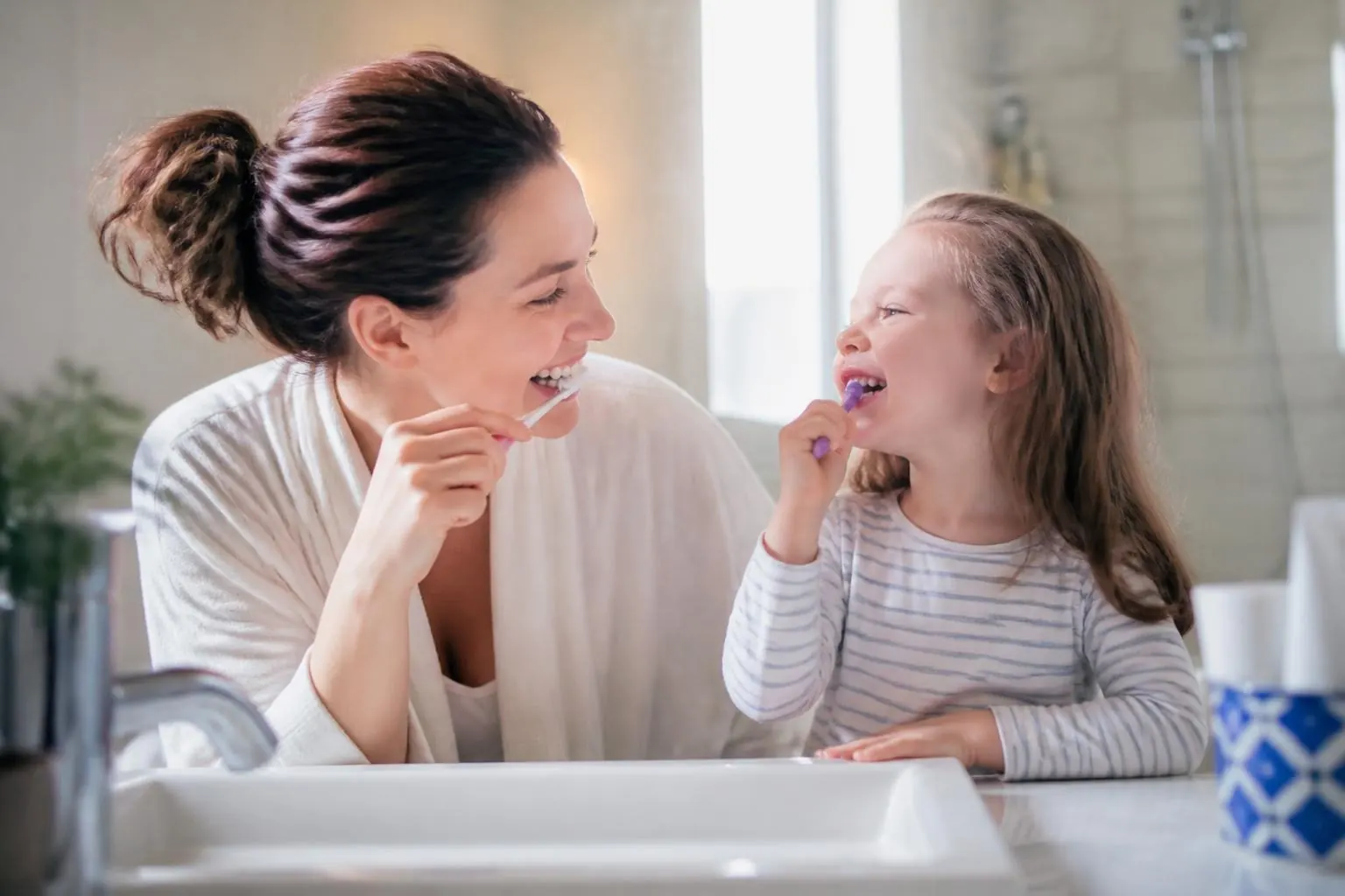 Mamá e hija cepillándose los dientes juntas