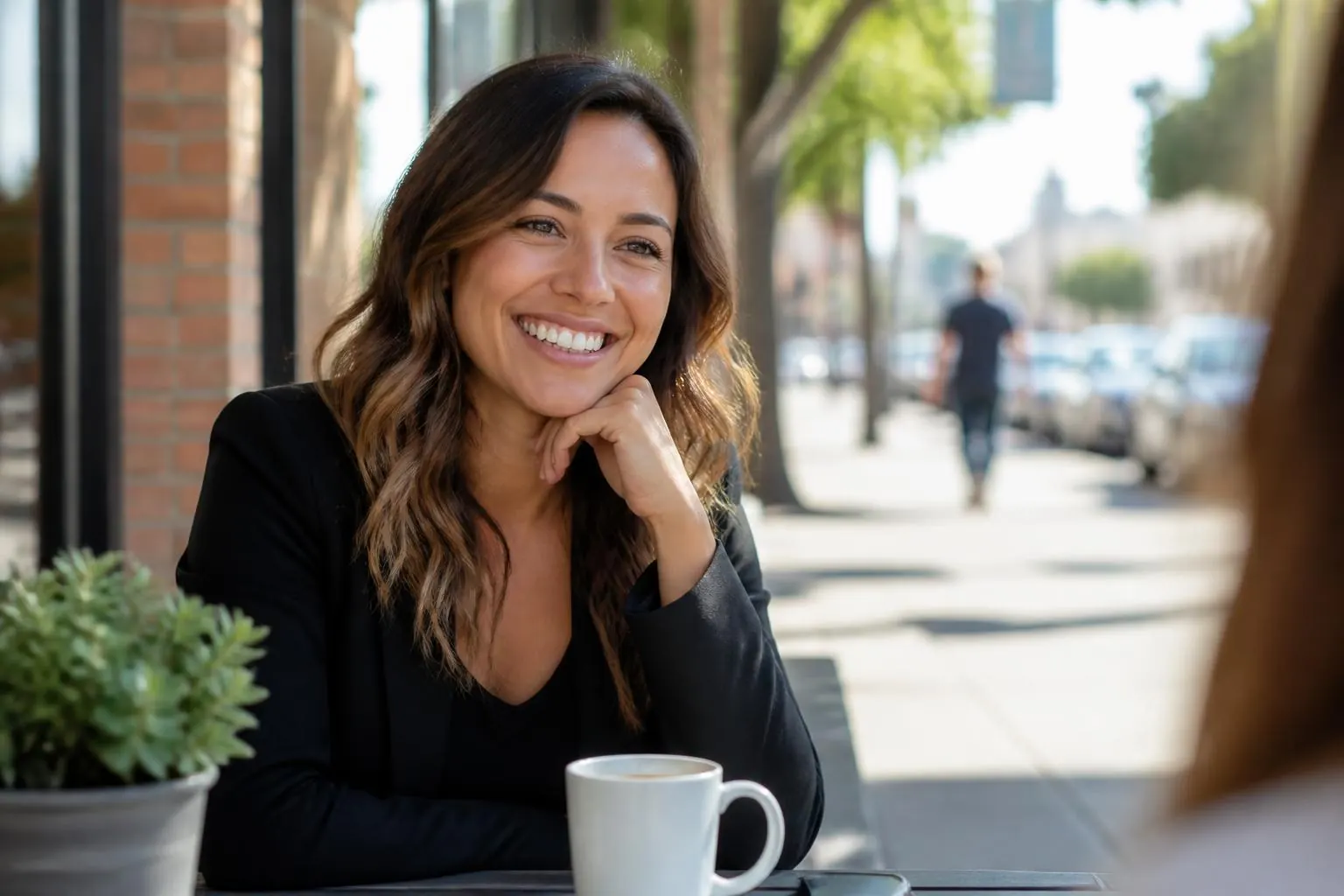 Mujer con una sonrisa radiante en un café al aire libre